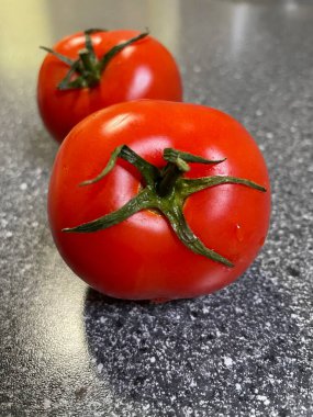 Karanlık bir arka plan üzerinde kırmızı domates.