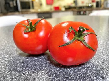 Siyah zemin üzerinde bıçak olan taze kırmızı domatesler.