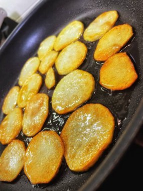 Çıtır çıtır patatesler, dilimler halinde dilimlenir, yağda kızartılır.