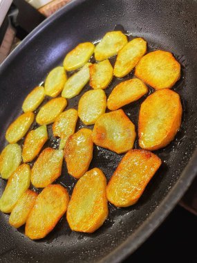 Çıtır çıtır patatesler, dilimler halinde dilimlenir, yağda kızartılır.