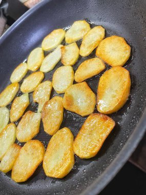 Çıtır çıtır patatesler, dilimler halinde dilimlenir, yağda kızartılır.