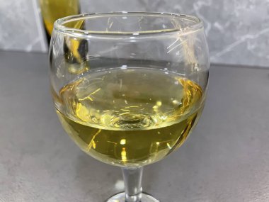 Bir kadeh beyaz şarap yakın.