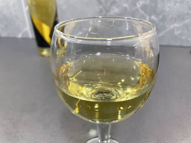 Bir kadeh beyaz şarap yakın.