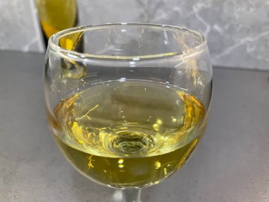 Bir kadeh beyaz şarap yakın.