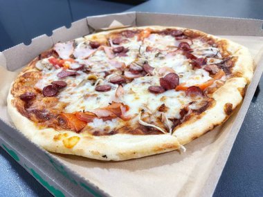 Mantarlı ızgara pizza, domates, salam, balyk ve erimiş peynir.