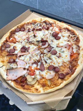 Mantarlı ızgara pizza, domates, salam, balyk ve erimiş peynir.