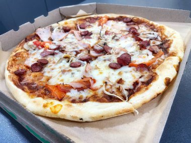 Mantarlı ızgara pizza, domates, salam, balyk ve erimiş peynir.