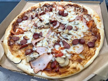 Mantarlı ızgara pizza, domates, salam, balyk ve erimiş peynir.