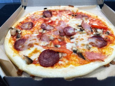 Mantarlı Francesca pizzası, domates, salam, balyk ve erimiş peynir.