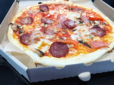 Mantarlı Francesca pizzası, domates, salam, balyk ve erimiş peynir.