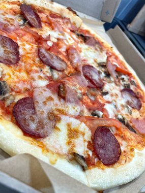 Mantarlı Francesca pizzası, domates, salam, balyk ve erimiş peynir.