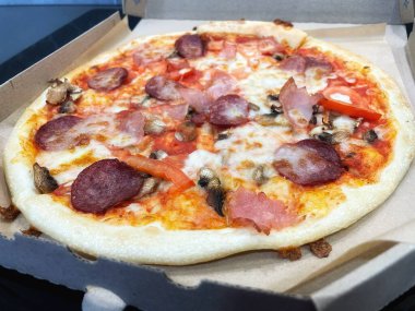 Beyaz arka planda peynirli ve pastırmalı pizza.