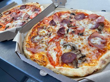 Tahta arka planda pizza ve peynirli pizza.