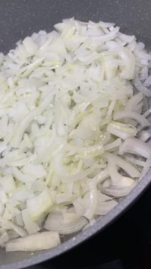 Yağ, yemek ve sebze dolu bir tavada kızartılmış ya da sotelenmiş soğan.