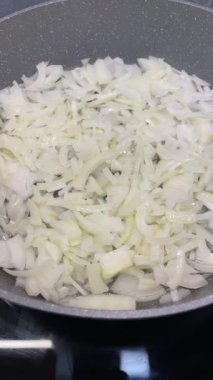 Yağ, yemek ve sebze dolu bir tavada kızartılmış ya da sotelenmiş soğan.