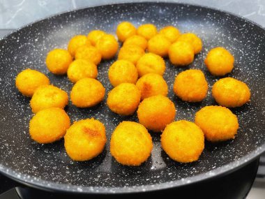 Kızarmış et ve peynir topları kızartma tavasında yağda kızartılır.