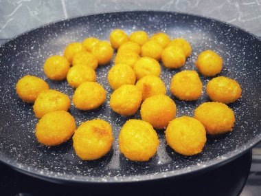 Kızarmış et ve peynir topları kızartma tavasında yağda kızartılır.