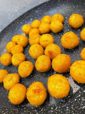 Kızarmış et ve peynir topları kızartma tavasında yağda kızartılır.