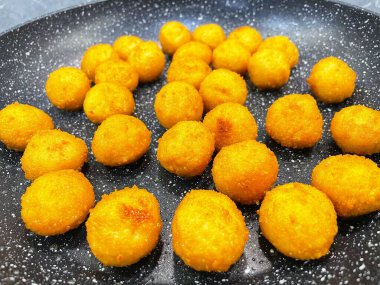 Kızarmış et ve peynir topları kızartma tavasında yağda kızartılır.