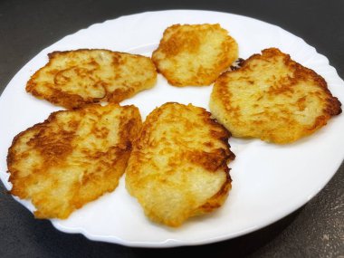 Patates tabağı, kızarmış patates gözlemesi, patates gözlemesi beyaz tabakta yatıyor.