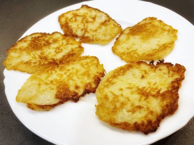 Patates tabağı, kızarmış patates gözlemesi, patates gözlemesi beyaz tabakta yatıyor.