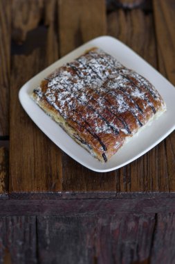 Karanlık vintage vooden masada çikolatalı kruvasan