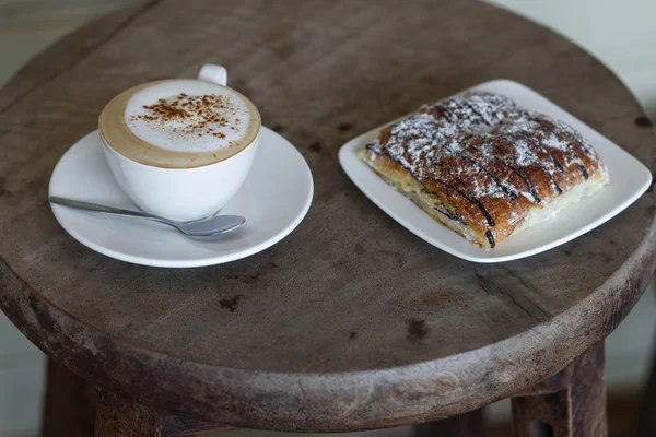 Cappuccino aroma con croissant de chocolate en la mesa redonda de madera vintage —  Fotos de Stock