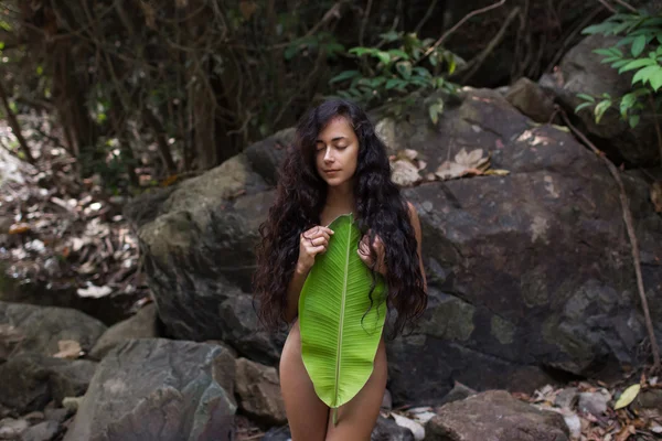 Bella giovane donna nuda nella giungla con foglia di palma — Foto Stock