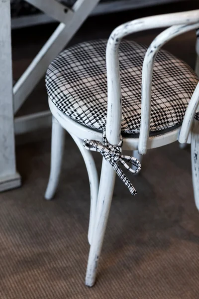 White vintage chair with squared pillow in cafe — Stock Photo, Image