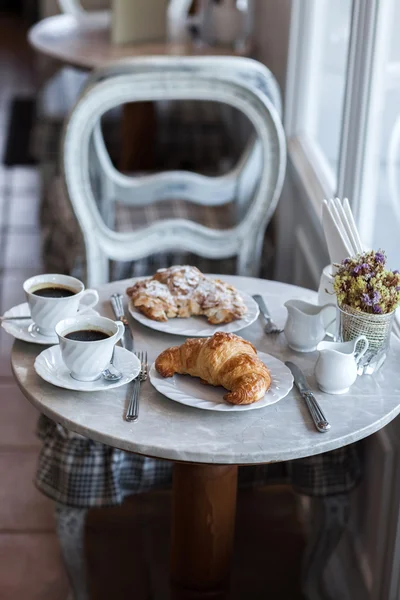 Frehcn café da manhã com croissants frescos e café quente na mesa branca — Fotografia de Stock