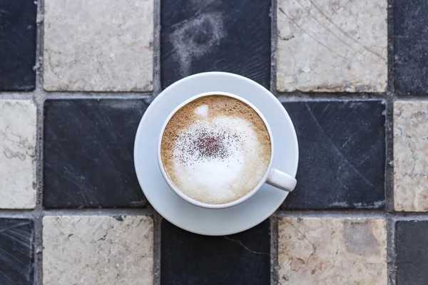 Cappuchino kőből faragva háttéren fehér csészében — Stock Fotó