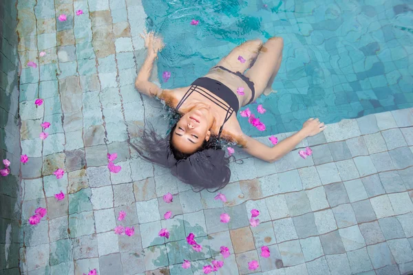 Bella donna sexy godendo in piscina di lusso in costume da bagno nero — Foto Stock