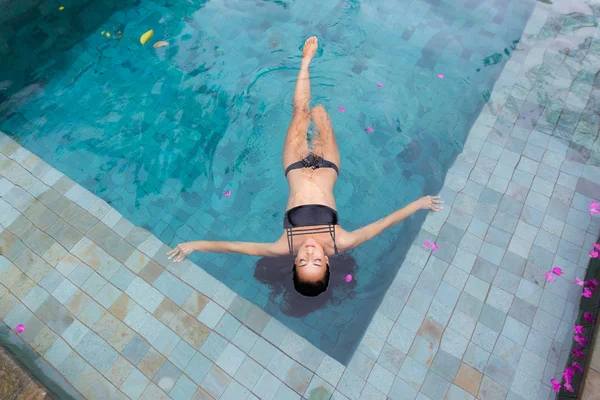 Bella donna sexy godendo in piscina di lusso in costume da bagno nero — Foto Stock