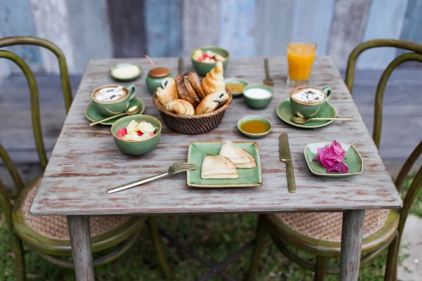 Café da manhã no jardim na mesa de madeira vintage — Fotografia de Stock