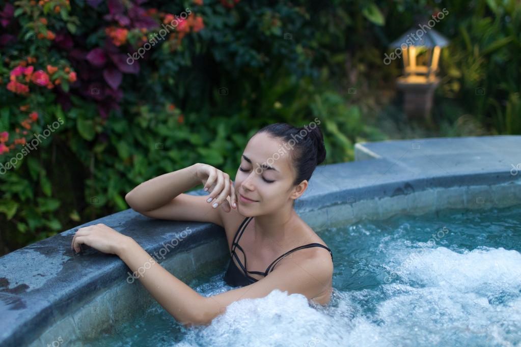 Jeune femme relaxante dans le jacuzzi image libre de droit par olegbreslavtsev © 104898888