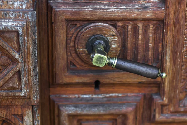 Vintage brons dörrhandtag på handgjorda träsnideri dörr — Stockfoto