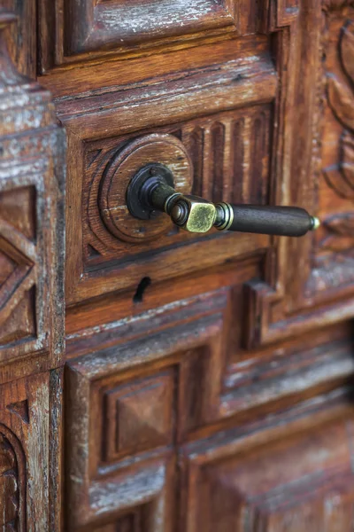 Винтажная бронзовая дверная ручка на ручной резьбе по дереву — стоковое фото