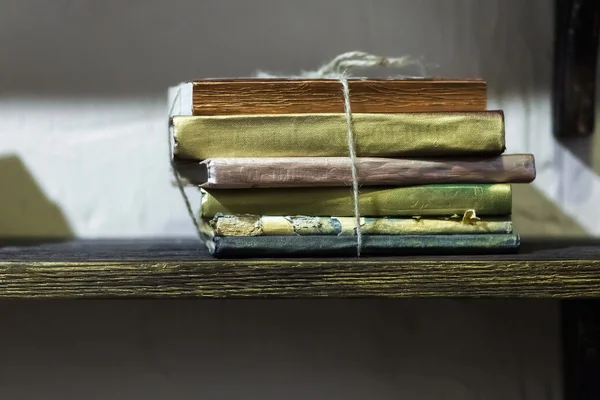 Montón de libros antiguos con cubiertas doradas en el estante —  Fotos de Stock