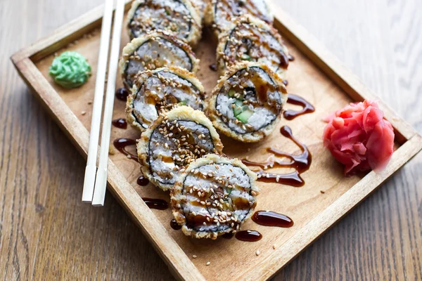 Pieczone sushi i rolki w drewnianą deskę z imbirem i zwieńczona sosie wasabi — Zdjęcie stockowe