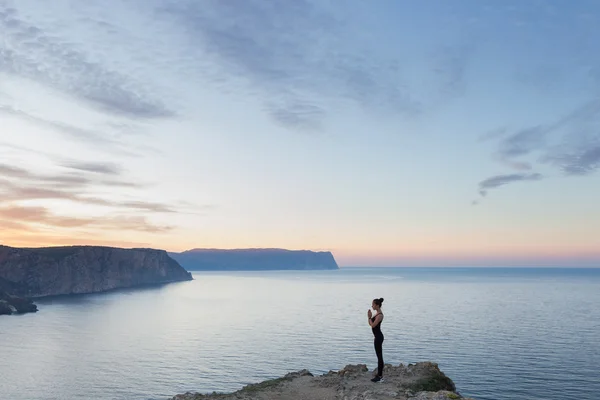 Mulher praticando ioga perto do mar — Fotografia de Stock