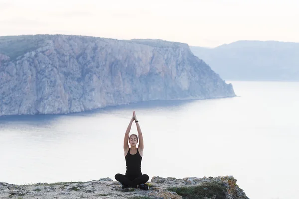 Woman practicing yoga near sea — Stock Photo, Image