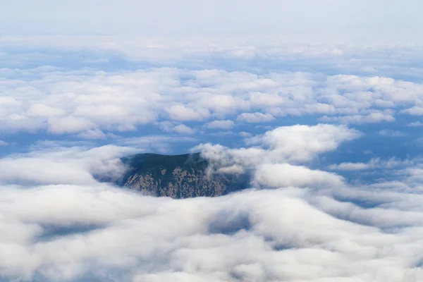 Top van bergen in de wolken — Stockfoto