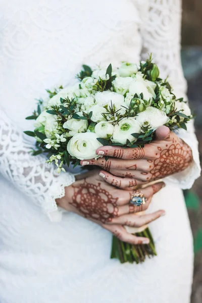 Bouquet in bride's hands with mehendi tattoo — Stock Photo, Image