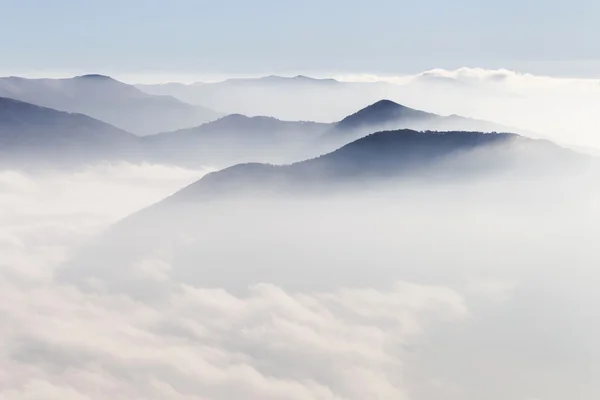 Silhouetten van bergen in de mist — Stockfoto