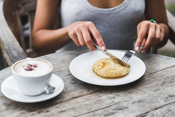 Frau isst Frühstück mit Bananen-Pfannkuchen — Stockfoto