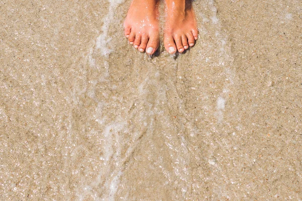 Frauenfüße im Meerwasser — Stockfoto