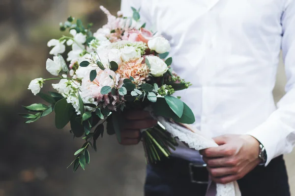 Noivo segurando buquê de casamento — Fotografia de Stock