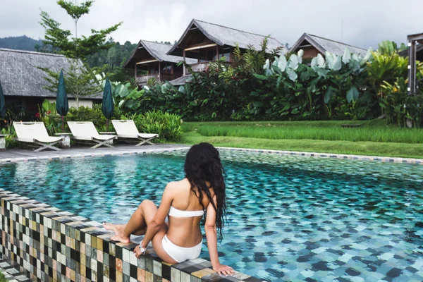 Beautiful girl enjoying at the edge of pool — Stock Photo, Image