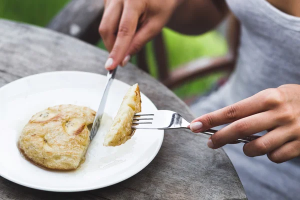 Mulher tomando café da manhã com panqueca de banana — Fotografia de Stock