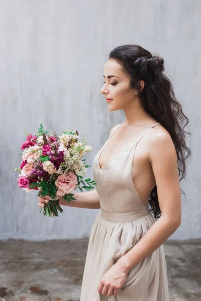 Braut im Seidenkleid mit Blumen — Stockfoto